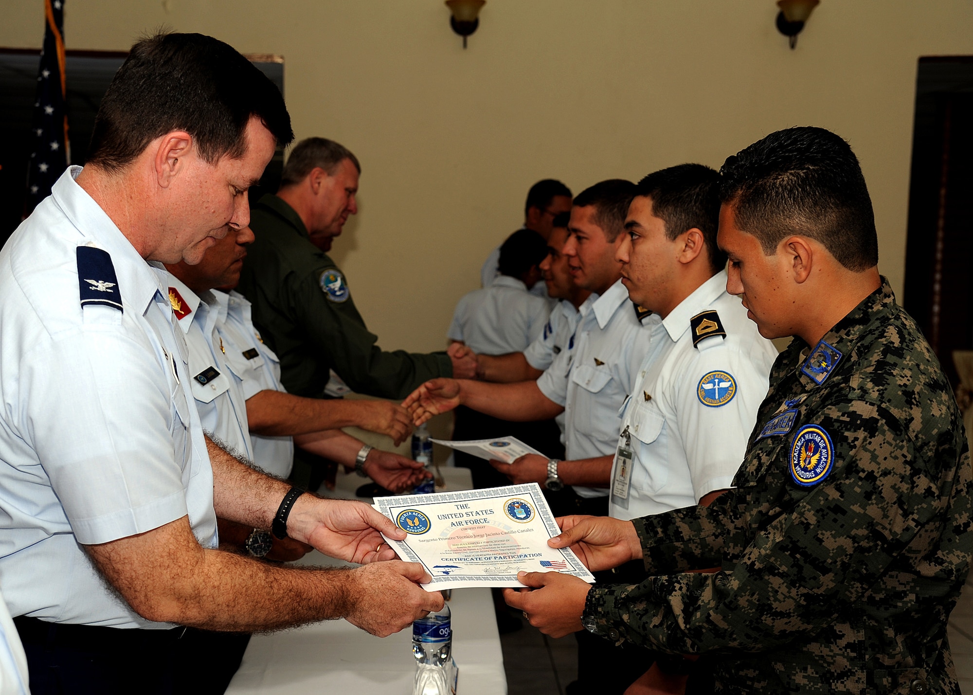 Colonel Gary Gottschall, 615th Contingency Response Wing commander, presents Sergeant First Class Jorge Jacinto Castillo Canales, Honduran air force member, with his certificate of participation during the closing ceremony, Tegucigalpa, Honduras, Feb. 23.  The building partner capacity mission, carried out by Air Mobility Command's two MSASs, was designed to promote regional stability by fostering key relationships and enhancing partner nation capabilities.  (U.S. Air Force photo by Tech. Sgt. Lesley Waters)