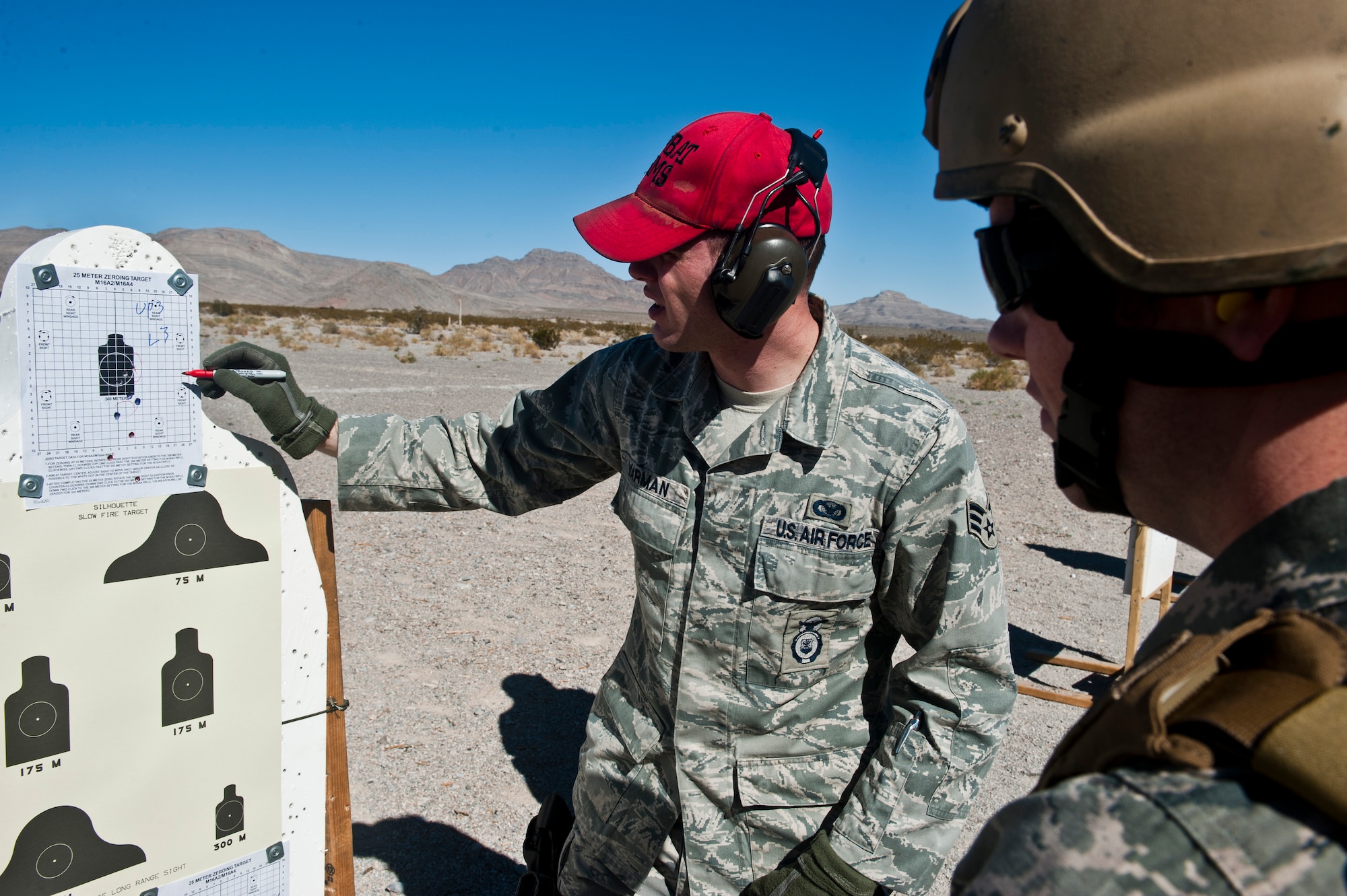 Senior Airman Nicholas Yarmen, 99th Security Forces Group combat arms instructor, reviews a firing score card with a shooter during combat arms training Feb. 24 at Nellis Air Force Base, Nev. The combat arms course curriculum changed Dec. 1, 2011. (U.S. Air Force photo by Senior Airman Jack Sanders)