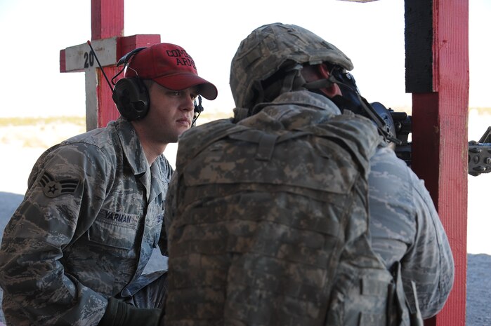 Senior Airman Nicholas Yarmen, 99th Security Forces Group combat arms instructor, monitors a shooter's form during combat arms training Feb. 24 at Nellis Air Force Base, Nev. The combat arms course curriculum changed Dec. 1, 2011. (U.S. Air Force photo by Senior Airman Jack Sanders)