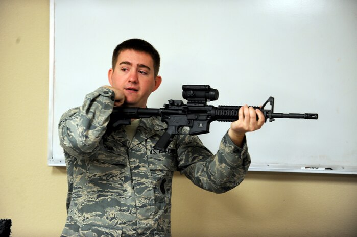 Airman 1st Class George Hudyma, 99th Security Forces Group combat arms instructor, demonstrates proper positioning of an M-4 carbine to a combat arms class Feb. 24 at Nellis Air Force Base, Nev. The combat arms course curriculum changed Dec. 1, 2011. (U.S. Air Force photo by Senior Airman Jack Sanders)
