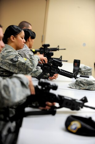 Airmen examine their weapons during a combat arms training course Feb. 24 at Nellis Air Force Base, Nev. Combat arms courses have recently undergone a change in course curriculum that was instated Dec. 1, 2011. (U.S. Air Force photo by Senior Airman Jack Sanders)