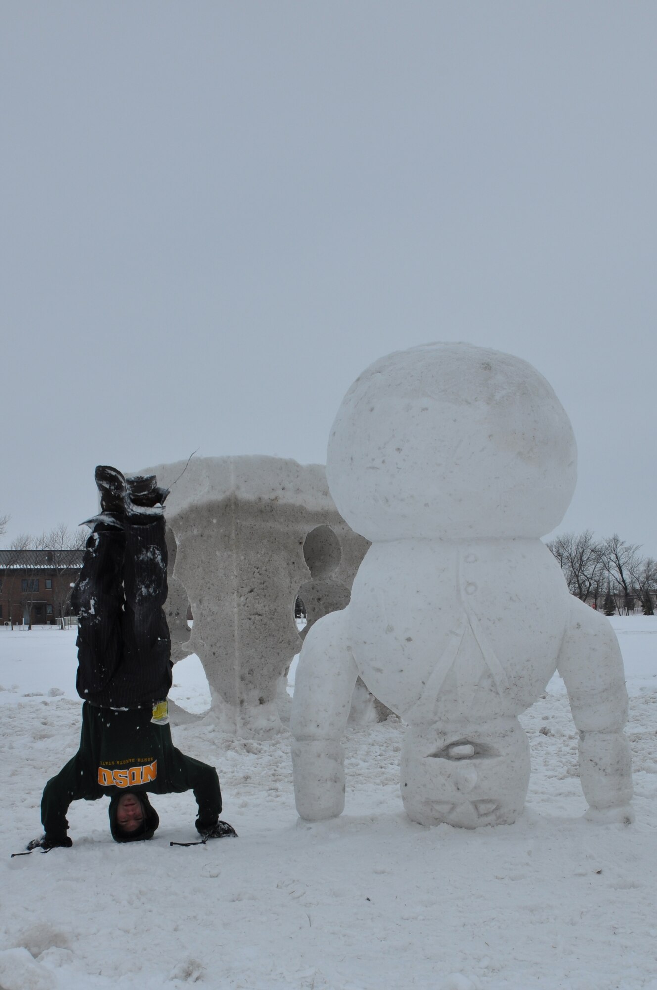 Kyle Slivnik, 319th Civil Engineer Squadron base community planner, poses for a photo alongside a snow sculpture he carved Feb. 22, 2012, on Grand Forks Air Force Base, N.D. Slivnik has competed internationally in competitions in both the U.S. and Canada. (U.S. Air Force photo/Airman 1st Class Derek VanHorn)