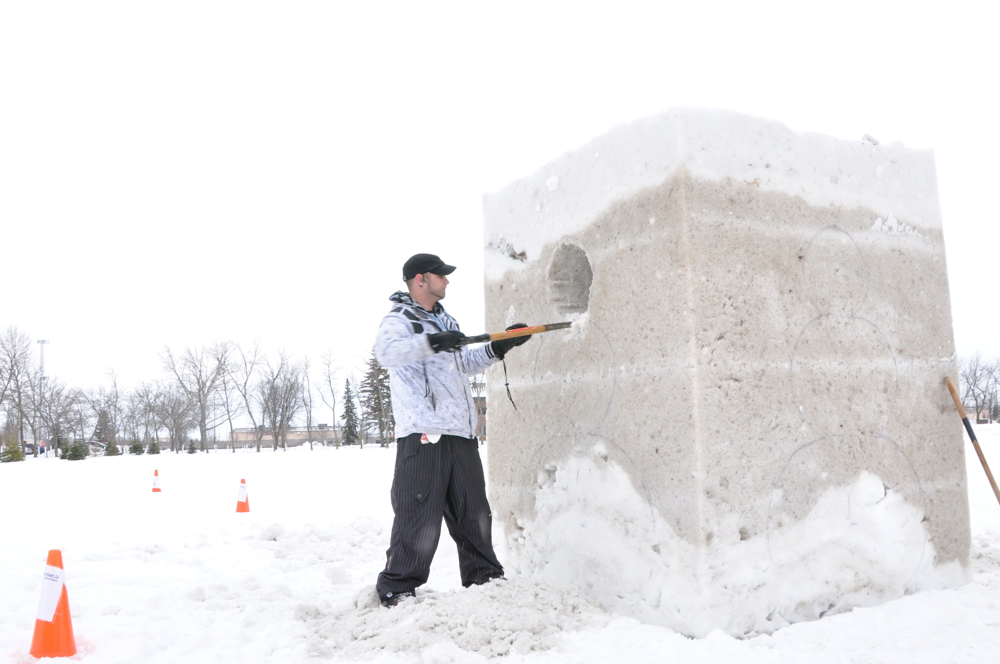 Kyle Slivnik, 319th Civil Engineer Squadron base community planner, works on a snow sculpture Feb. 22, 2012, on Grand Forks Air Force Base, N.D. The sculpture was a four-sided snowman silhouette and was submitted as an entry for the Iceman Competition during the base's annual Winter Bash on Feb. 23, 2012. (U.S. Air Force photo/Airman 1st Class Derek VanHorn)