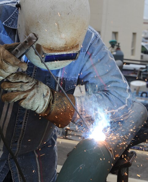 Bobby Mitchell, a contracted welder, welds two pipes together on Barksdale Air Force Base, La., Feb. 28. The pipes were fabricated to make a pipeline for a chiller next to the 2nd Logistics Readiness Squadron building. A chiller is a machine that removes heat from liquid through vapor compression. (U.S. Air Force photo/Airman 1st Class Micaiah Anthony)(RELEASED) 