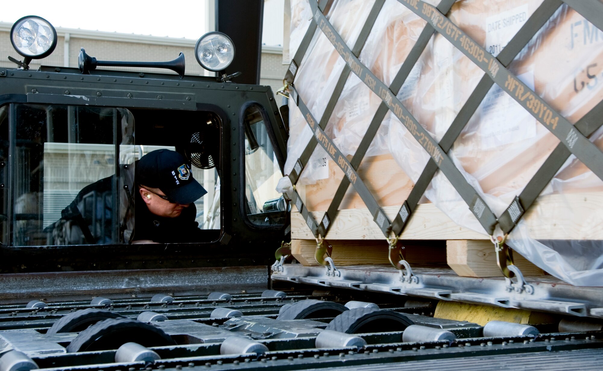 Jeff Lohrfink, a motor vehicle operator with the 436th Aerial Port Squadron, watches for clearance while guiding cargo pallets onto a 60K Tunner Aircraft Loader, Feb. 10, 2012, at Dover Air Force Base, Del. (U.S. Air Force photo by Master Sgt. Jeanette Spain)