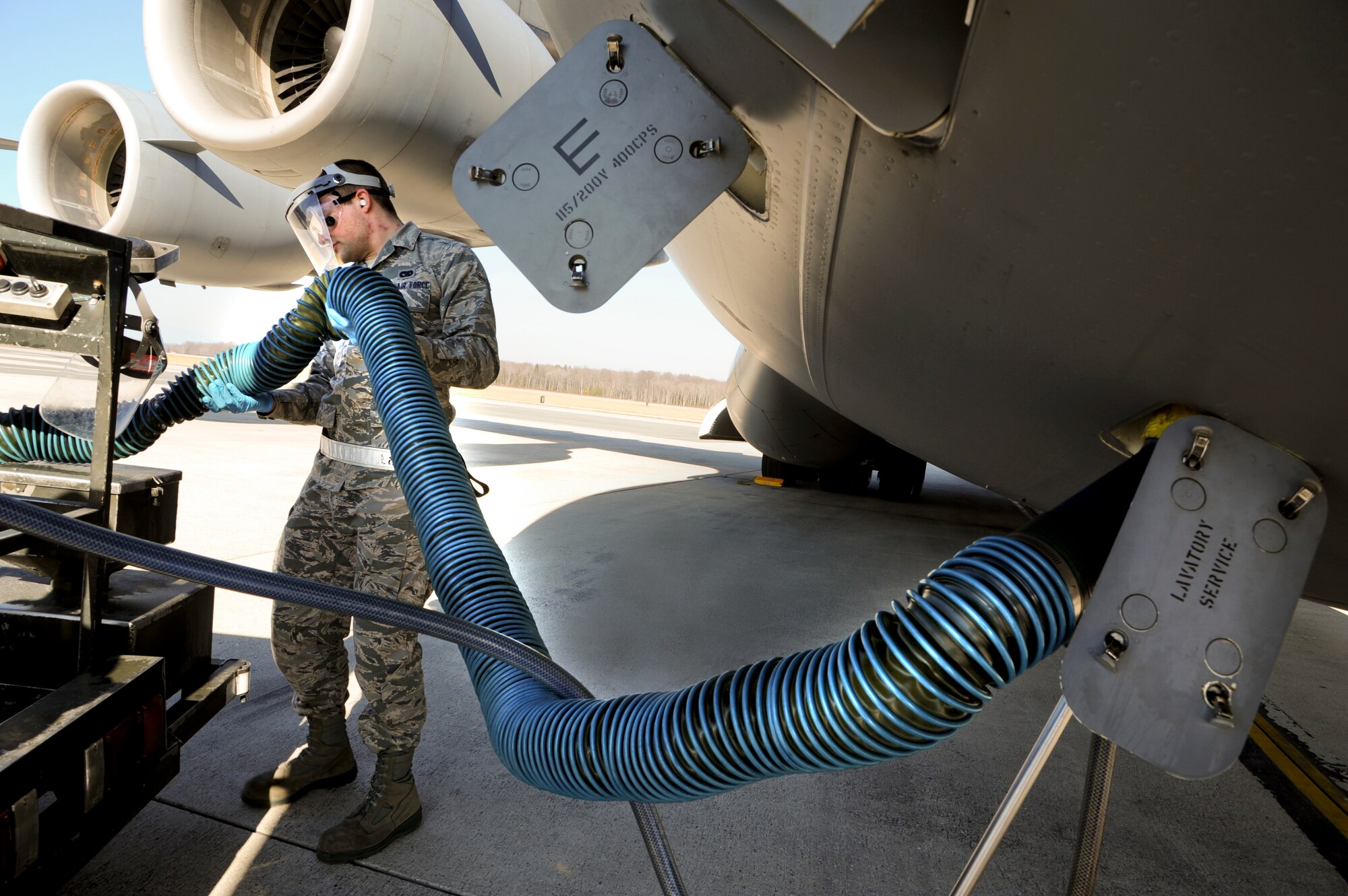 Airman Michael Kirsch, a Ramp Services transporter with the 436th Aerial Port Squadron, connects a waste hose to a C-17 Globemaster III during a lavatory-servicing operation on the flightline, Feb. 13, 2012, at Dover Air Force Base, Del. Fleet Services, a subdivision of Ramp Services, ensures all aircraft at Dover AFB, are clean and serviceable for aircrews and passengers 24 hours a day, 365 days a year. (U.S. Air Force photo by Master Sgt. Jeanette Spain)