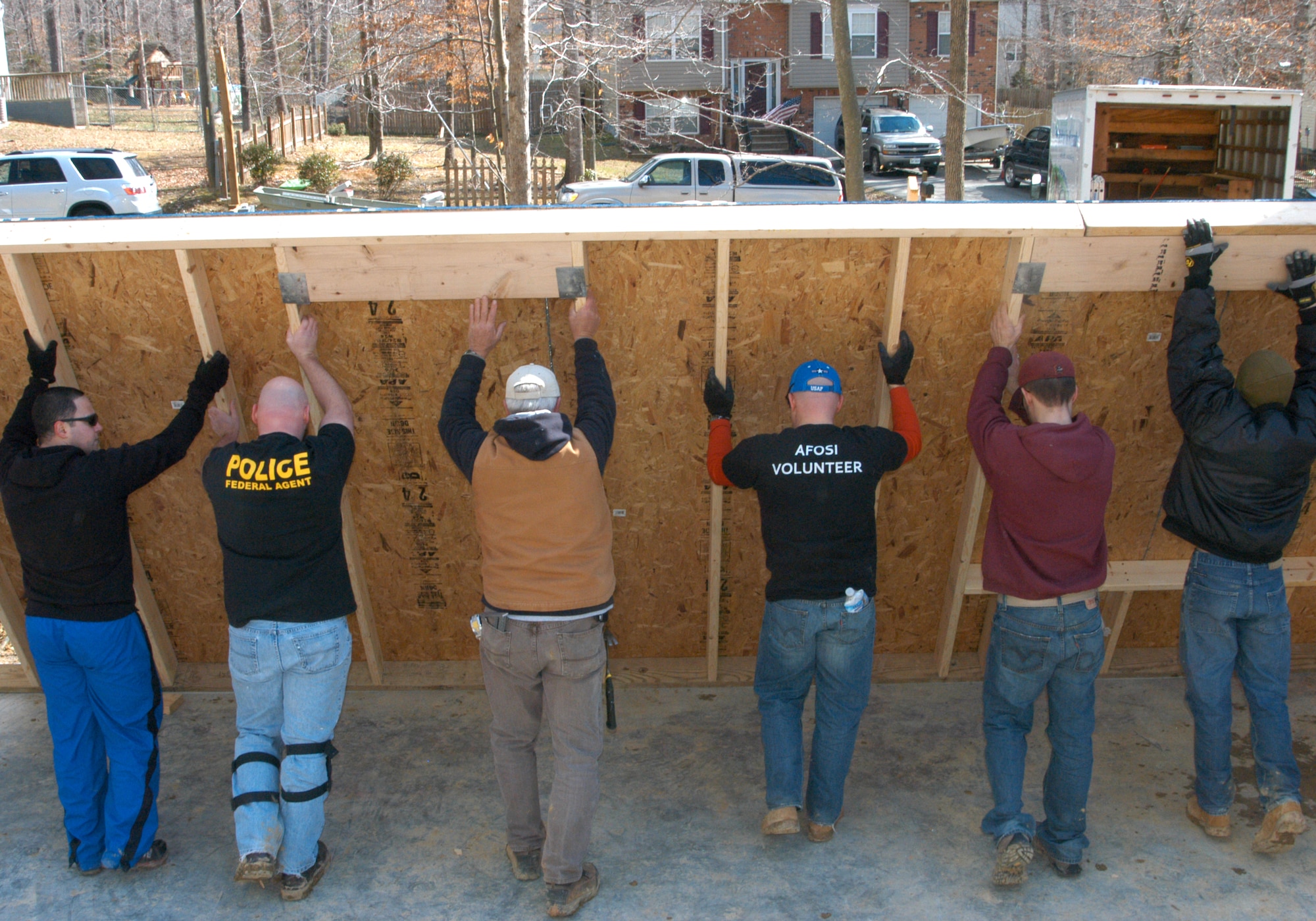 OSI volunteers and Habitat for Humanity workers raise the third wall of a Habitat home Feb. 23. OSI volunteers spent the day working on the home and a storage building behind it. (U.S. Air Force photo by Mr. James C. Dillard.) 
