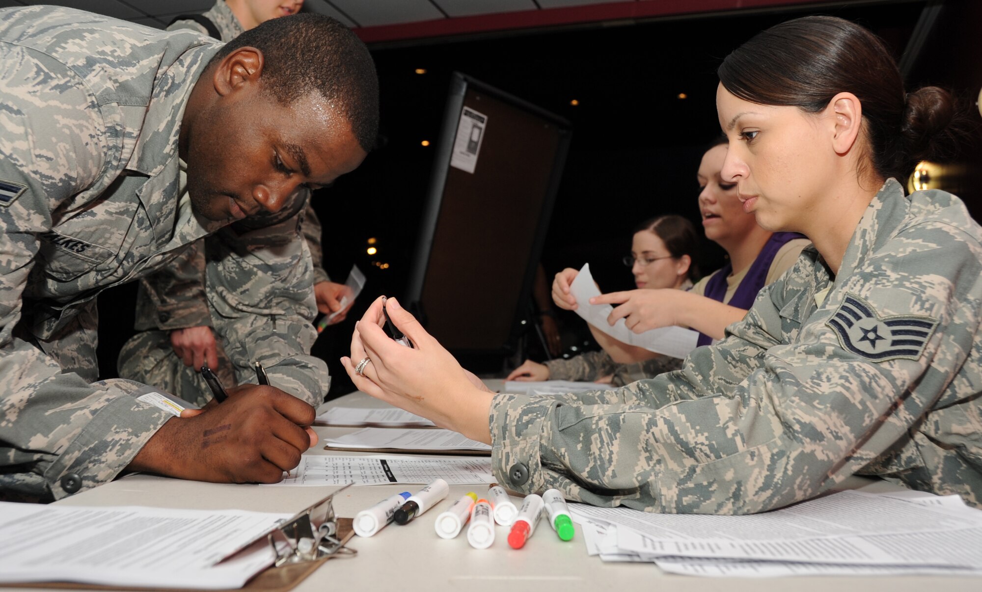 Airman 1st Class Jeremy Walkes, 338th Training Squadron, signs a patient administration form with the assistance of Staff Sgt. Consuelo Patterson, 81st Medical Support Squadron, after receiving “medication” for his “symptoms” during a disease contaminant plan exercise Feb. 23, 2012, at the Vandenburg Community Center, Keesler Air Force Base, Miss.  (U.S. Air Force photo by Kemberly Groue)