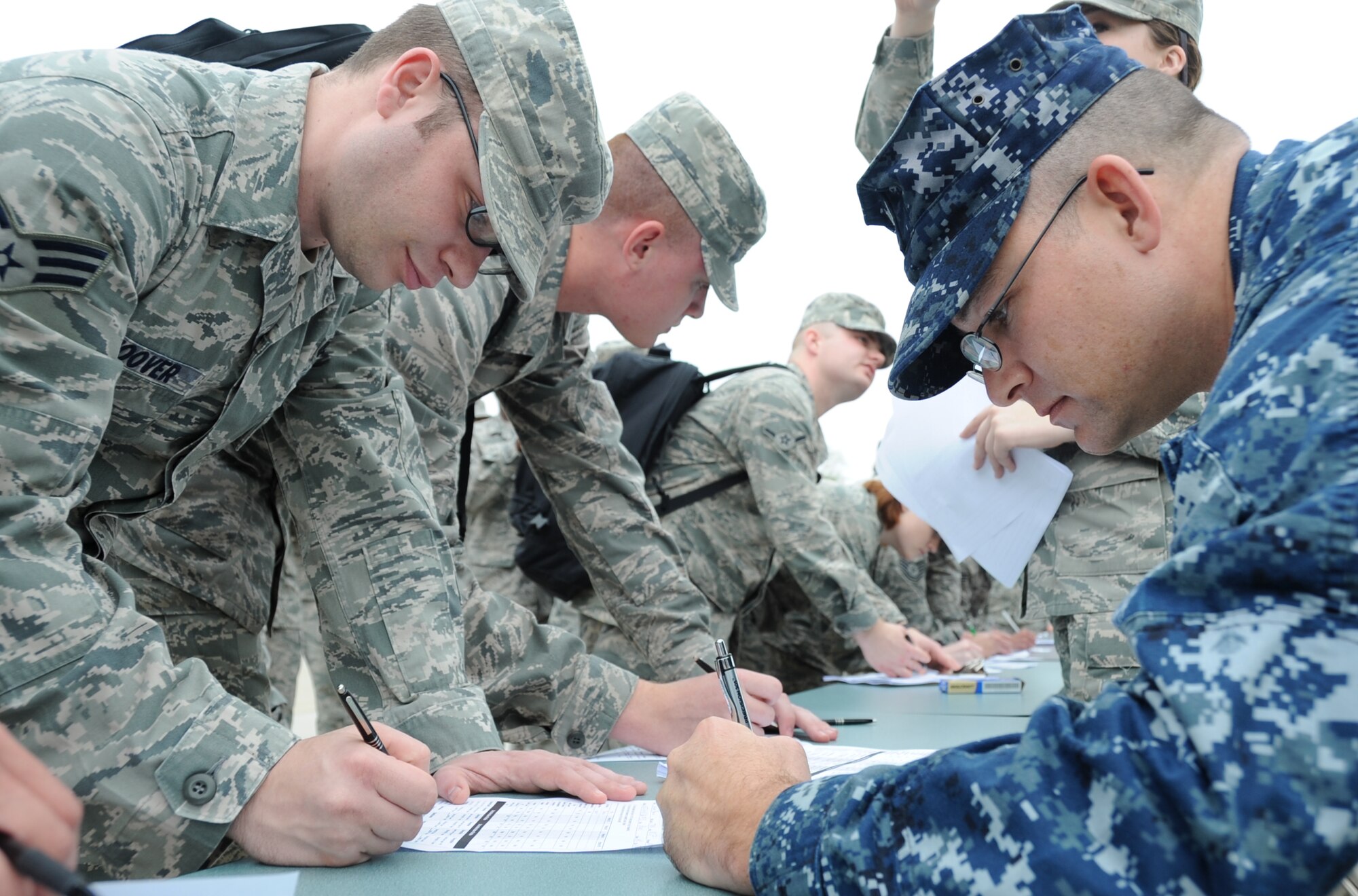 Senior Airman Joshua Hoover, 81st Training Wing command post; Airman Basic Ian Shoup, 338th Training Squadron, and Petty Officer 1st Class Brian Riordan, 81st Medical Group Navy and Marine Corps liaison, fill out patient administration forms during a disease contaminant plan exercise Feb. 23, 2012, at the Vandenburg Community Center, Keesler Air Force Base, Miss.  (U.S. Air Force photo by Kemberly Groue)