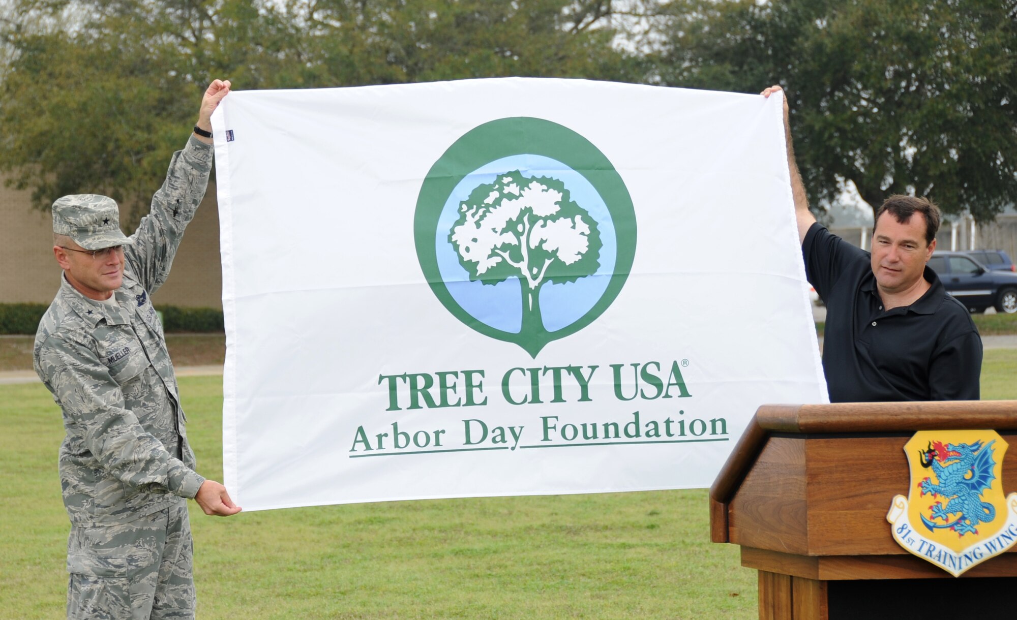 Brig. Gen. Andrew Mueller, 81st Training Wing commander, is presented a Tree City USA award by Rick Bradley, Jackson County Mississippi Urban Forest Council Commission, during an Earth Arbor Day ceremony Feb. 23, 2012, at the Child Development Center, Keesler Air Force Base, Miss.  (U.S. Air Force photo by Kemberly Groue)