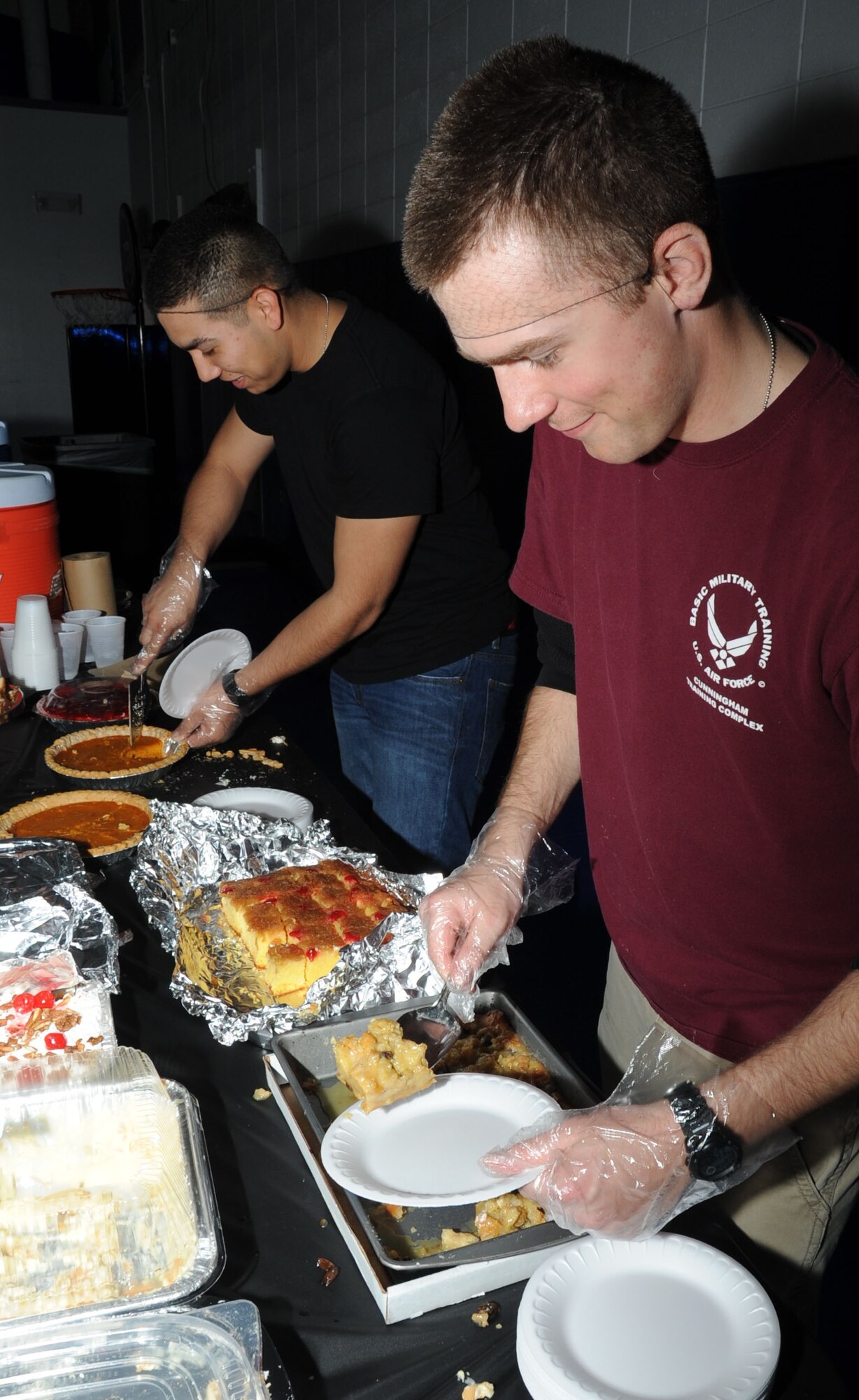 Airman 1st Class Kevin Donis and Airman Basic William McCarren, 336th Training Squadron, serve desserts during the African American Heritage Committee soul food sampling Feb. 24, 2012, at the youth center, Keesler Air Force Base, Miss.  (U.S. Air Force photo by Kemberly Groue)