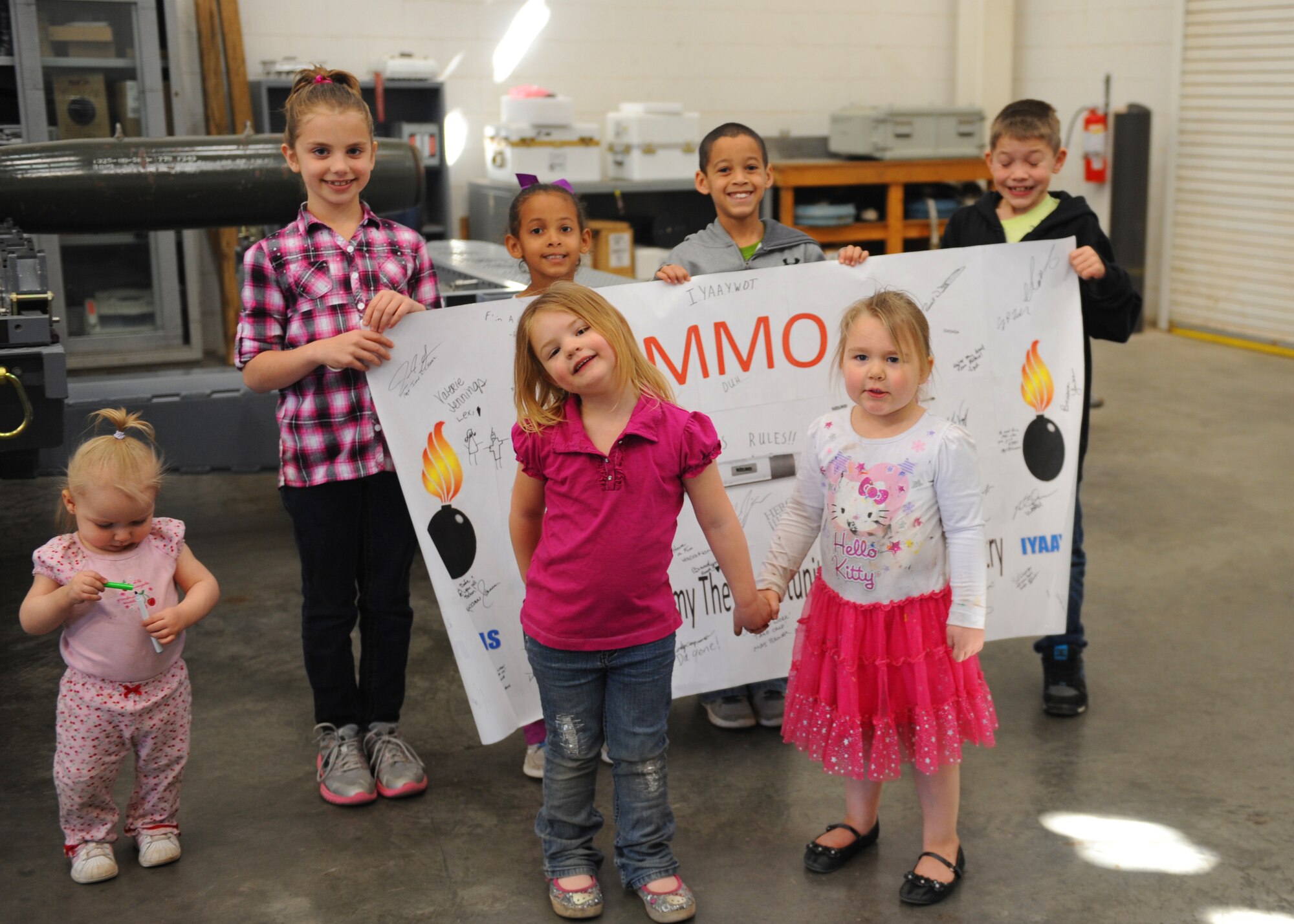 Children of deployed Airmen from the 7th Munitions Squadron, pose for a picture in front of a handmade poster for deployed Airmen from 7 MUNS, Feb. 25, 2012, at Dyess Air Force Base, Texas. The children painted pictures and made gifts for deployed Airmen from 7 MUNS. (U.S. Air Force photo by Airman 1st Class Cierra Bullock/Released)