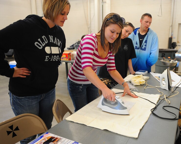 Valerie Jennings, center, irons her picture onto a pillow case as a decorative gift for her deployed husband, Feb. 25, 2012, at Dyess Air Force Base, Texas. Jennings’ spouse, U.S. Air Force Staff Sgt. Drake Jennings, 7th Munitions Squadron, is currently deployed to Southwest Asia. (U.S. Air Force photo by Airman 1st class Cierra Bullock/Released)