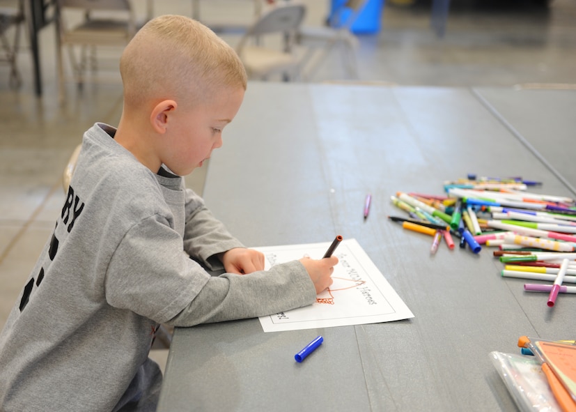 Harry Briner, son of U.S. Air Force Maj. John Briner, 7th Munitions Squadron commander, colors a card for deployed Airmen, Feb. 25, 2012, at Dyess Air Force Base, Texas. Children and spouses 7 MUNS participated in making care packages for deployed Airmen. (U.S. Air Force photo by Airman 1st Class Cierra Bullock/Released)