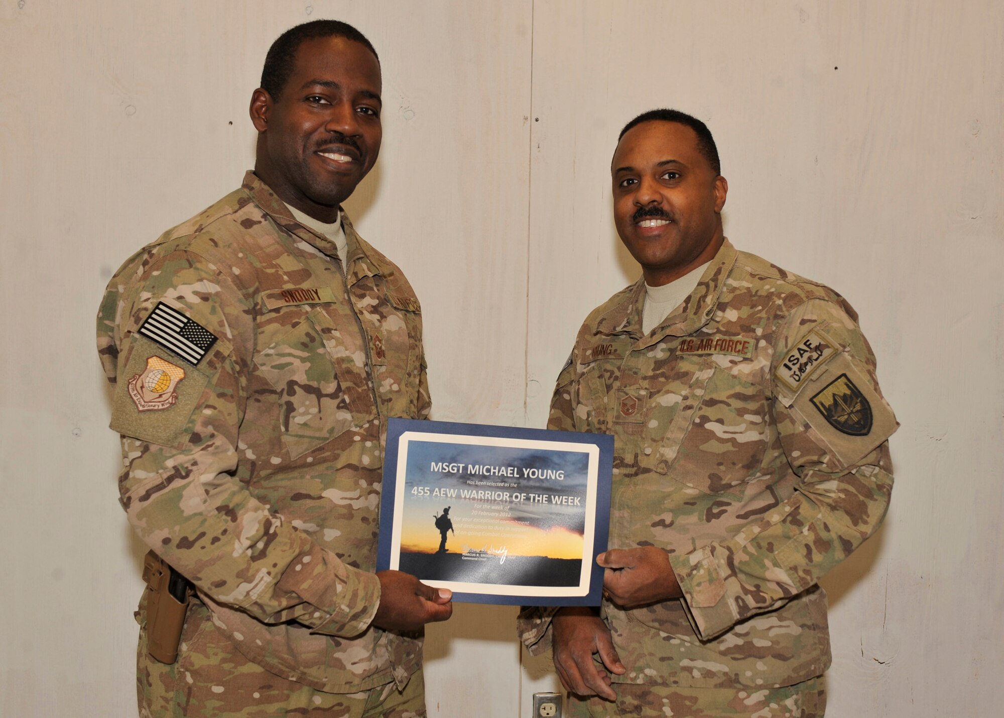 BAGRAM AIRFIELD, Afghanistan— Master Sgt. Michael Young receives the Warrior of the Week award from Command Chief Master Sgt. Marcus Snoddy at Bagram Airfield, Afghanistan, Feb. 28, 2012. Young is a noncommissioned officer in charge of the commander support staff with the 577th Expeditionary Prime Base Engineer Emergency Force Squadron and earned the Warrior of the Week award for his hard work and dedication to excellence. (U.S. Air Force photo/Airman 1st Class Ericka Engblom)