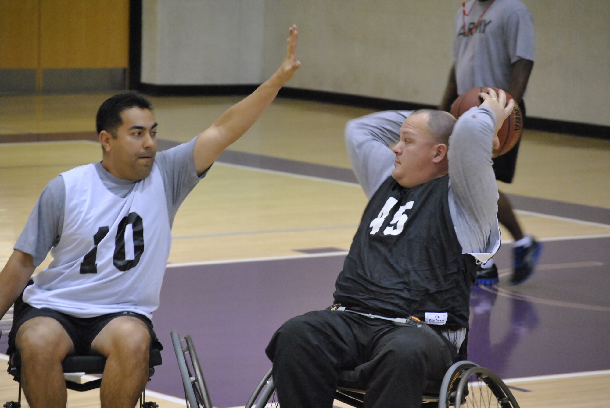 U.S. Army Chief Warrant Officer 4 Manuel Molina of 1st Platoon attempts to block Sgt. Jason McCord of 2nd Platoon from making a pass to one of his teammates during wheel-chair basketball action of the Warrior Transition Unit’s Adaptive Sports Day recently hosted at the McClellan Fitness Center at Fort Eustis, Va. The mission of the WTU is to provide care and case management for Soldiers in transition to establish the conditions for their healing, and to promote their timely return to the force or transition to civilian life. (Photo by Selvin C. Walker)