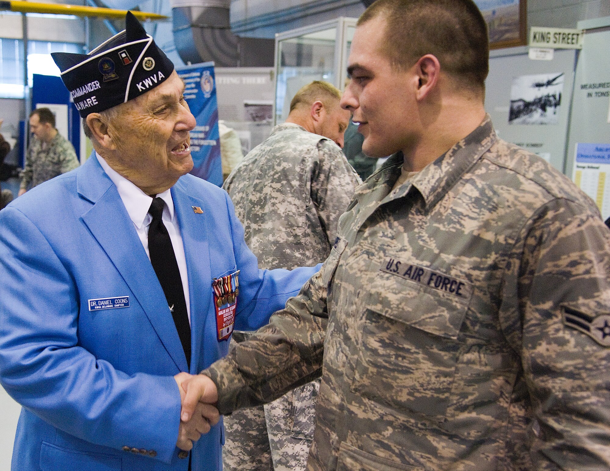 Dan Coons, left, the state commander of the Korean War Veterans' Association, shakes hands with Airman 1st Class Marcus Lopez, 436th Aerial Port Squadron, Feb. 25, 2012, at the Dover Air Force Base, Del., Air Mobility Command Museum. Team Dover members met with Korean War veterans during the 13th Annual Korean War Remembrance Ruck March to honor troops who served in the “Forgotten War.” (U.S. Air Force photo by Airman 1st Class Samuel Taylor) 