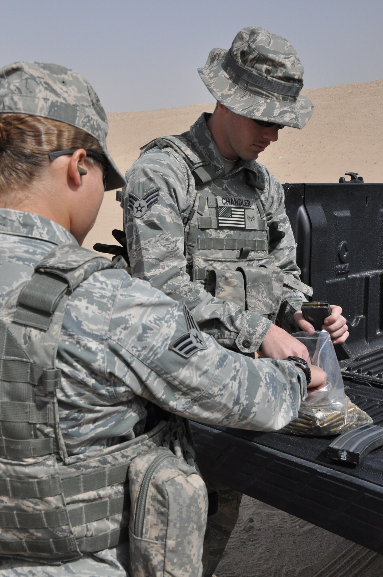 SOUTHWEST ASIA -- Senior Airman Jessika Hill and Senior Airman Kevin Chandler, 332nd Expeditionary Security Forces Squadron members, load ammunition into magazines to prepare for their next round of firing training Feb. 24, 2012 at an undisclosed location in Southwest Asia. Hill and Chandler are a part of the security escort team, which ensures Airmen get to and from their destination safely when traveling off-base. They are deployed from Kirtland Air Force Base, N.M. Hill is a native of Baltimore and Chandler is a native of Jackson, Miss. (U.S. Air Force photo by Senior Airman Melanie Holochwost/Released)