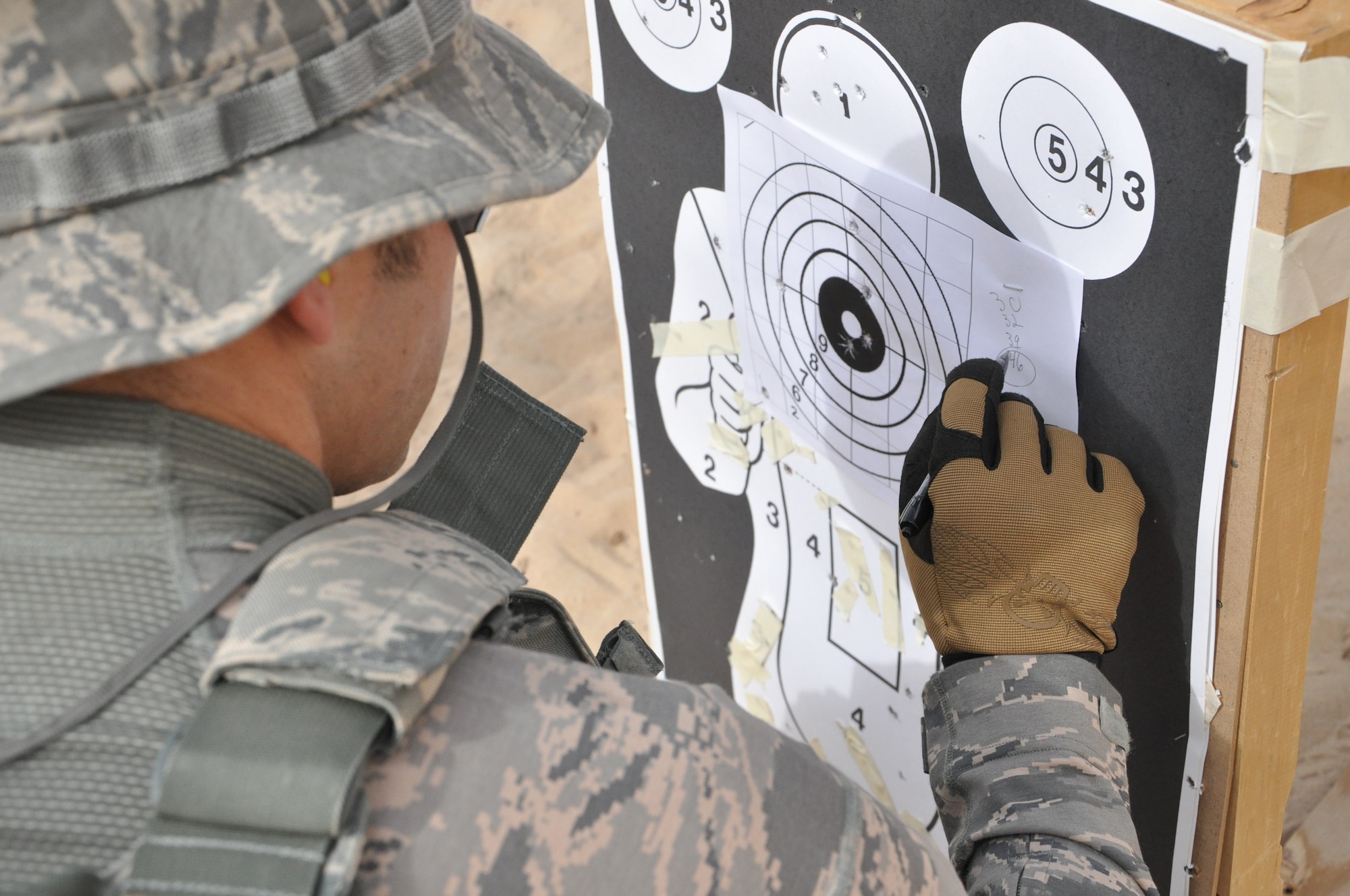 SOUTHWEST ASIA -- Tech. Sgt. Derrik Morris, 332nd Expeditionary Security Forces Squadron member, grades one of his team members on marksman skills Feb. 24, 2012 at an undisclosed location in Southwest Asia.Although defenders are only required to fire twice a year during weapons qualification, the security escort team practices marksmanship at least once a month. Morris is deployed from Kirtland Air Force Base, N.M., and is a native of Madras, Ore.  (U.S. Air Force photo by Senior Airman Melanie Holochwost/Released)