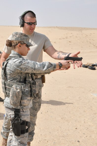 SOUTHWEST ASIA – Staff Sgt. Todd Waite, 332nd Expeditonary Security Forces Squadron combat arms instructor, shows Senior Airman Jessika Hill, 332nd ESFS member, how to improve her firing accuracy Feb. 24, 2012 at an undisclosed location in Southwest Asia. Waite is deployed from Holloman Air Force Base, N.M., and is a native of Jackson, Mich. Hill is deployed from Kirtland Air Force Base, N.M., and is a native of Baltimore. (U.S. Air Force photo by Senior Airman Melanie Holochwost/Released)