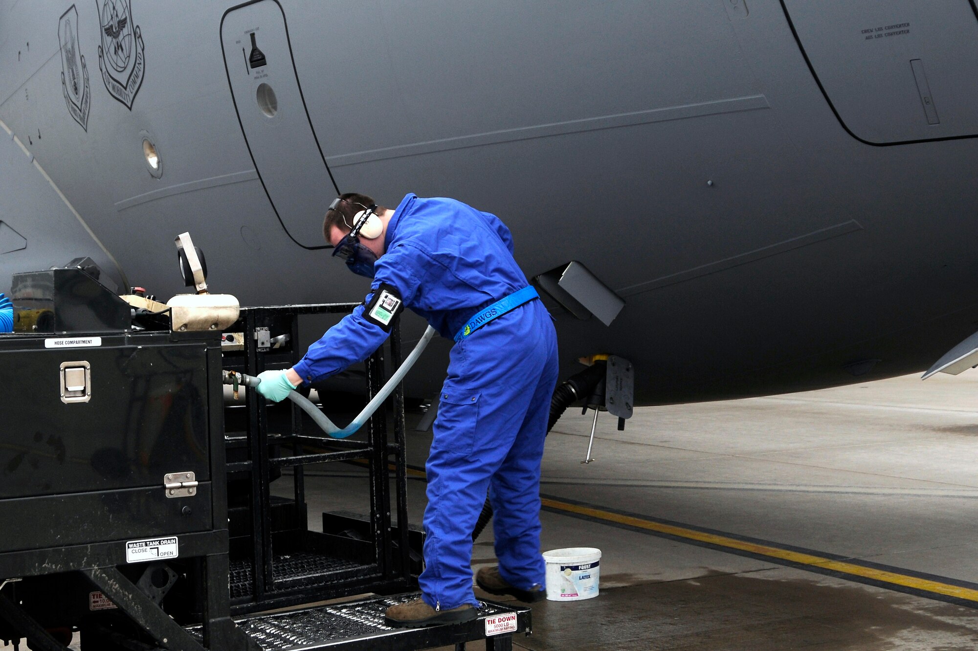 Airman 1st Class Evan Hughes attaches the “blue juice” hose to rinse out the lavatory tank and to fill up the charge tank of a C-17 Globemaster III, Ramstein Air Base, Germany, Feb. 23, 2012. This process is accomplished on every aircraft in transit through Ramstein ensuring that every plane is cleaned prior to taking off again. (U.S. Air Force photo by Airman 1st Class Trevor Rhynes.)