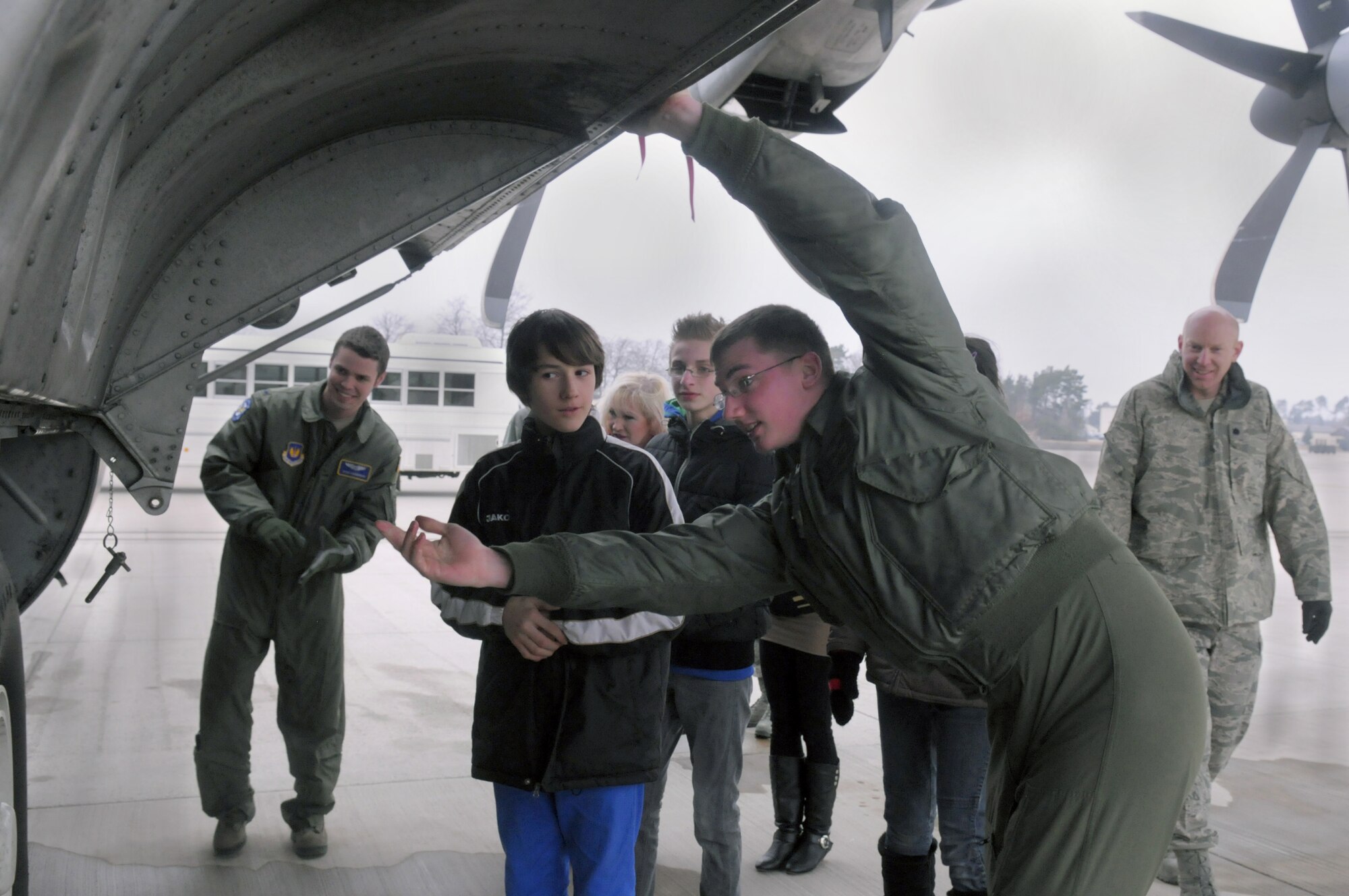 Airman 1st Class John Temmen, 37th Airlift Squadron loadmaster shows Jan, an orphan in the St. Nikolaus Kinderheim in Landstuhl, Germany, the underside of a C-130J on Ramstein Air Base, Germany, Feb. 23. Jan and two other orphans from the orphanage received a tour of Ramstein facilities to give them a better insight of how the United States generates air power in Germany. (U.S. Air Force photo/Staff Sgt, Travis Edwards)