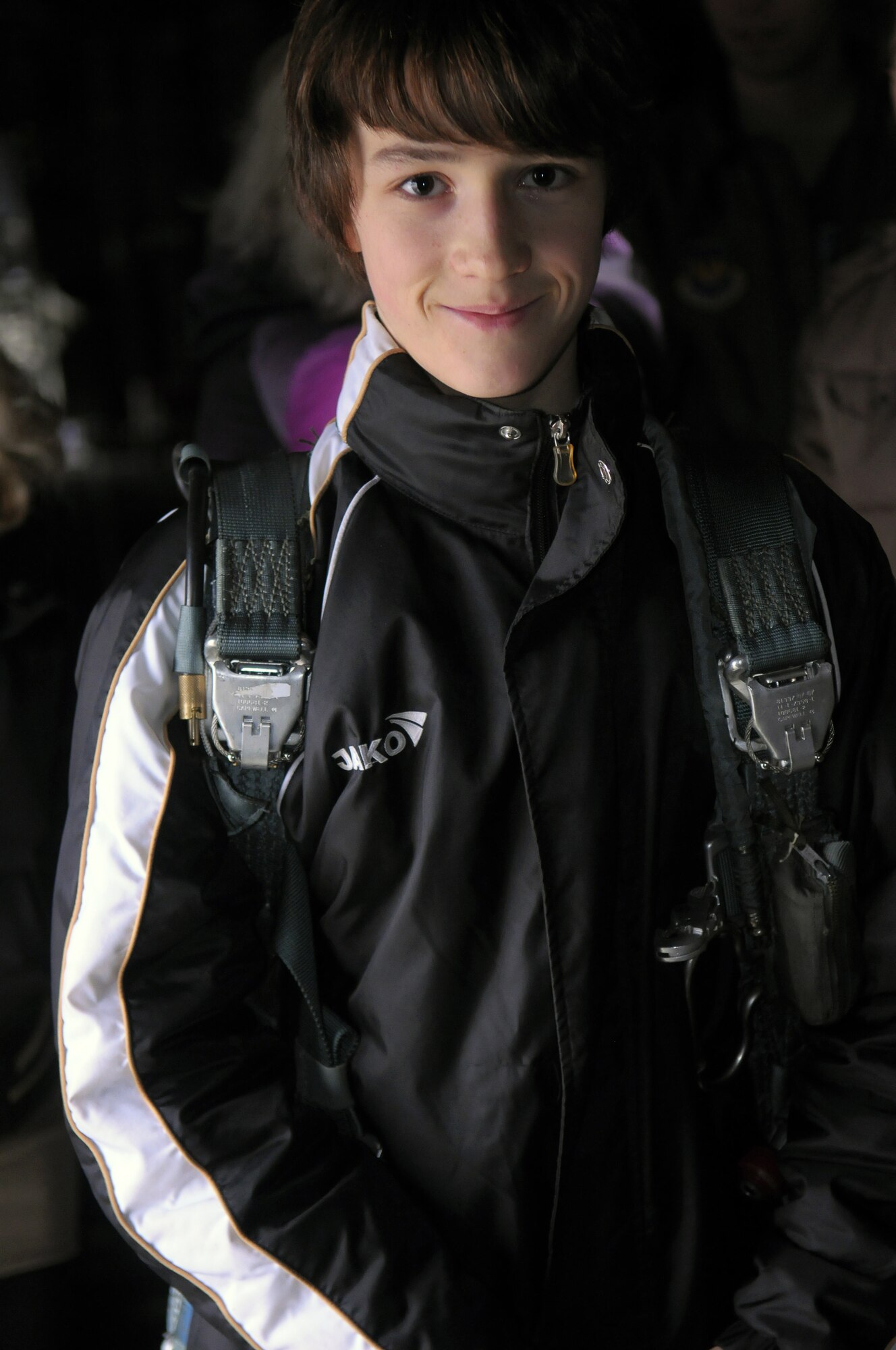 Jan, an orphan in the St. Nikolaus Kinderheim in Landstuhl, Germany, poses with a 22-pound crew parachute on a C-130J on Ramstein Air Base, Germany, Feb. 23. Jan and two other orphans from the orphanage received a tour of Ramstein facilities to learn about what the United States does in Germany. (U.S. Air Force photo/Staff Sgt, Travis Edwards)