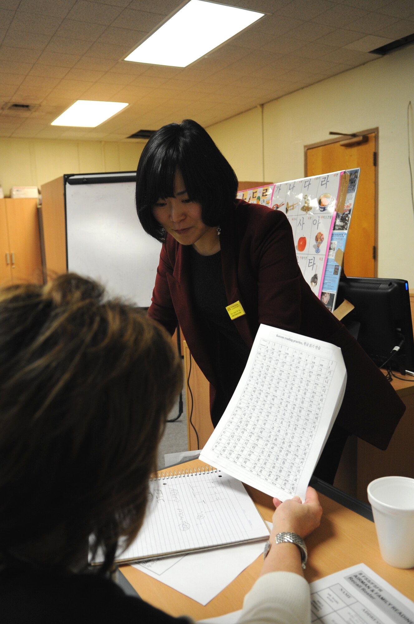 Kim Son-kyong, Airman and Family Readiness Center teacher, explains the rules of Hangul to a student Feb. 14, 2012, at Kunsan Air Base, Republic of Korea. As part of the class, students learned the Korean pronunciation and written symbols for their names. (U.S. Air Force photo by Senior Airman Brigitte N. Brantley/Released)