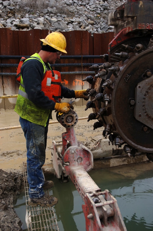 A construction worker with Treviicos-Soletanche Joint Venture inspects the teeth on a hydromill at Wolf Creek Dam in Jamestown, Ky., Feb. 8, 2012.  The U.S. Army Corps of Engineers Nashville District is overseeing the installation of a concrete barrier wall as part of a foundation remediation project that will fix seepage issues. (USACE photo by Leon Roberts)