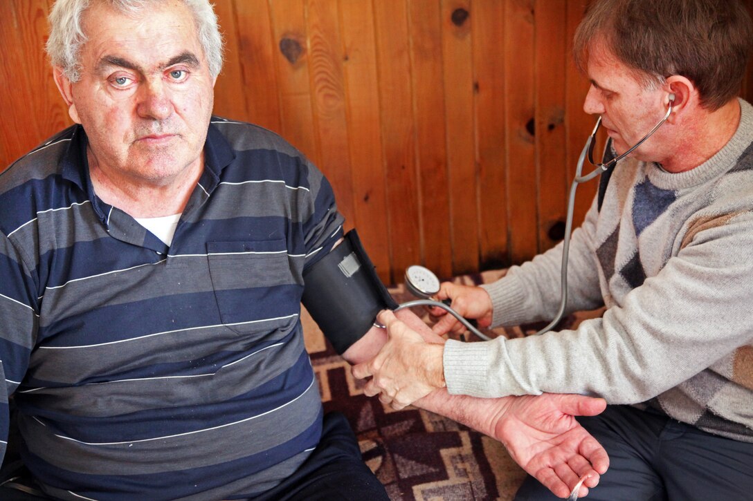 Dr. Darko Nisavic, right, a physician with a Montenegrin emergency medical team, examines a resident of Trsa, Montenegro, Feb. 23, 2012.