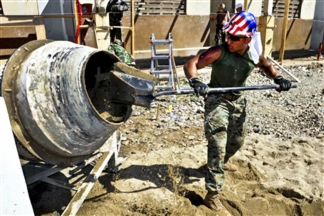 U.S. Marine Corps Staff Sgt. Mario Vargas shovels cement into a mixer to make concrete at the National School of Caracol in Caracol, Haiti, on Feb. 22, 2012.  U.S. and Indonesian engineers are refurbishing a dispensary and school as part of Southern Partnership Station 2012, a deployment of U.S naval assets in the Caribbean, Central and South America.  
