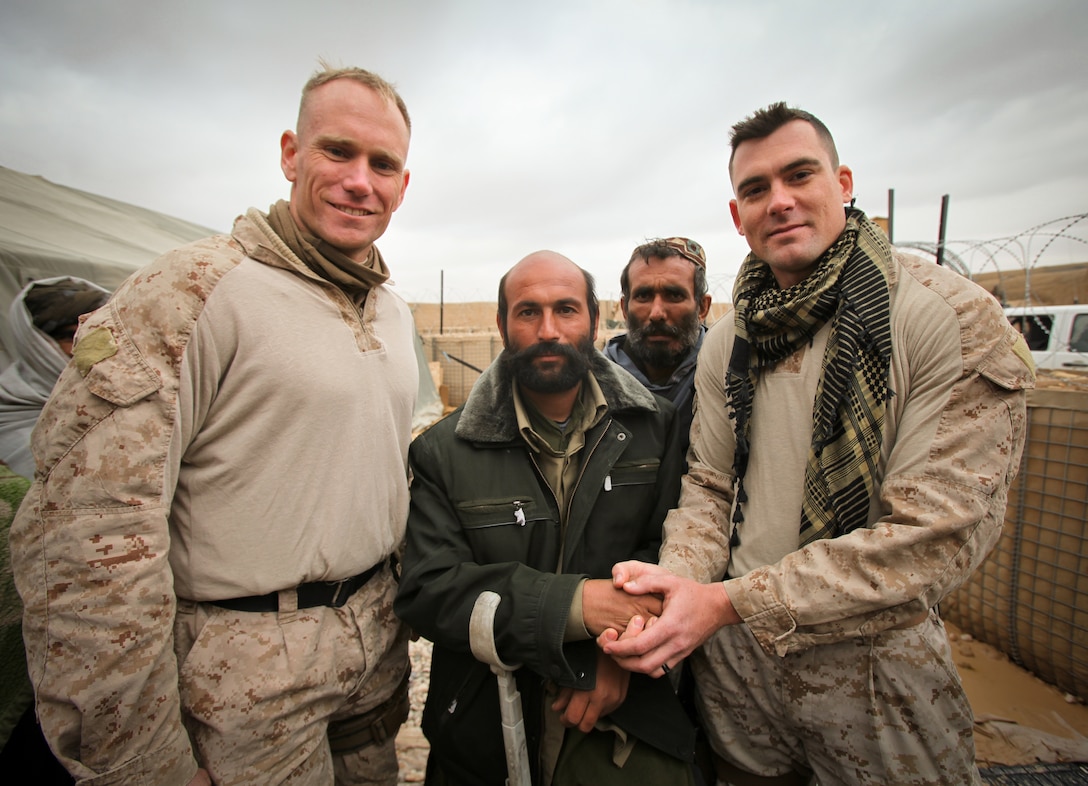 Capt. Chad Lowry (left), and Staff Sgt. Christopher (right),  take a photo with Rhamatooli who is the Afghan Local Police commander for Forward Operating Base Rahim located in northern Nahr-e-Saraj District, Helmand province. The two pay agents from Regional Command Southwest’s Afghan National Security Force Development Team recently travelled throughout Helmand province to pay members of the Afghan Local Police.