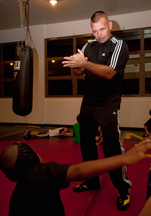 MARINE CORPS BASE HAWAII -Master Sgt. Timothy D. Greenleaf, war reserve chief, G-4, U.S. Marine Corps Forces, Pacific, shows one of his wrestlers how to perform a butterfly grip during a wrestling practice April 11 at the Division Schools Martial Arts Center here. Greenleaf has spent the past 18 years coaching numerous youth sports teams and is currently the head coach for Marine Corps Base Hawaii’s Marine Corps Community Services youth wrestling team.