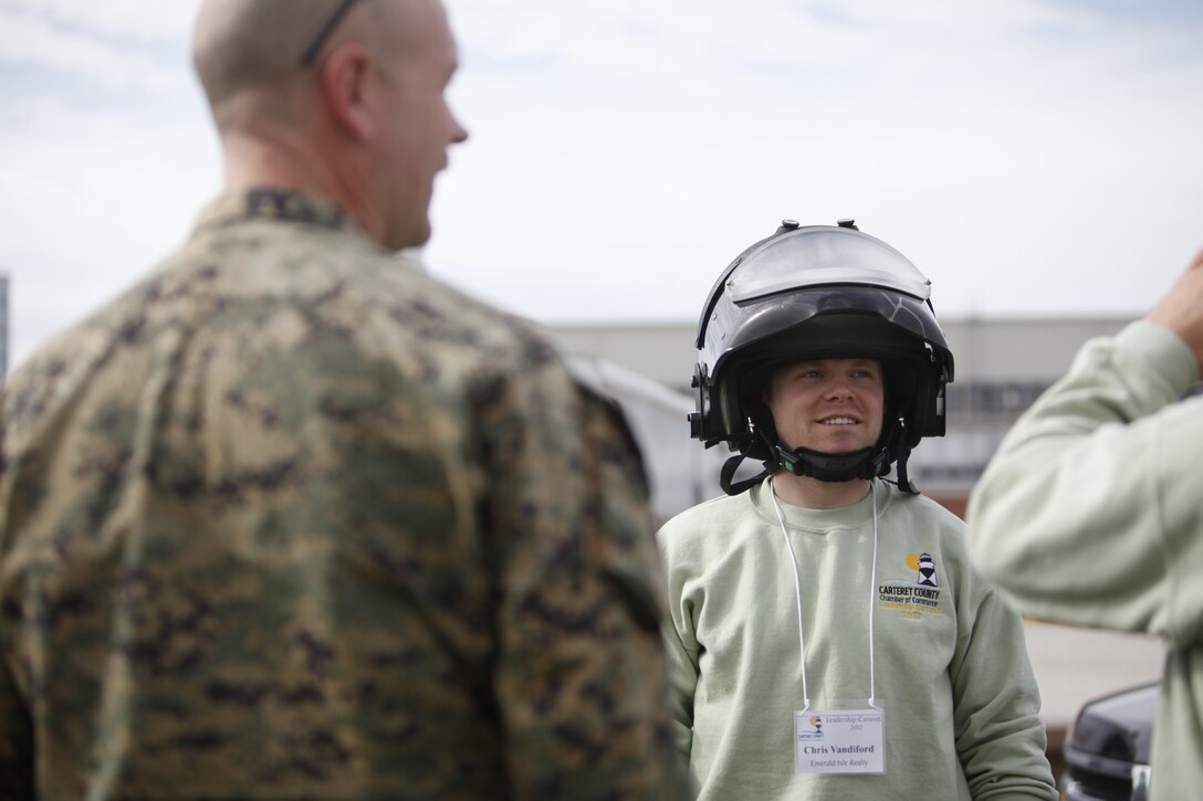 Christopher S. Vandiford, the director of maintenance with Emerald Isle Realty based out of Emerald Isle, N.C., tries on a helmet that belongs to one of Explosive Ordinance Disposal's bomb diffusing suits, during a tour of Marine Corps Air Station Cherry Point Feb. 29. Vandiford is a member of the Carteret County Chamber of Commerce Executive Leadership Program. The group came aboard the air station to gain insight into what Cherry Point Marines and Sailors do.