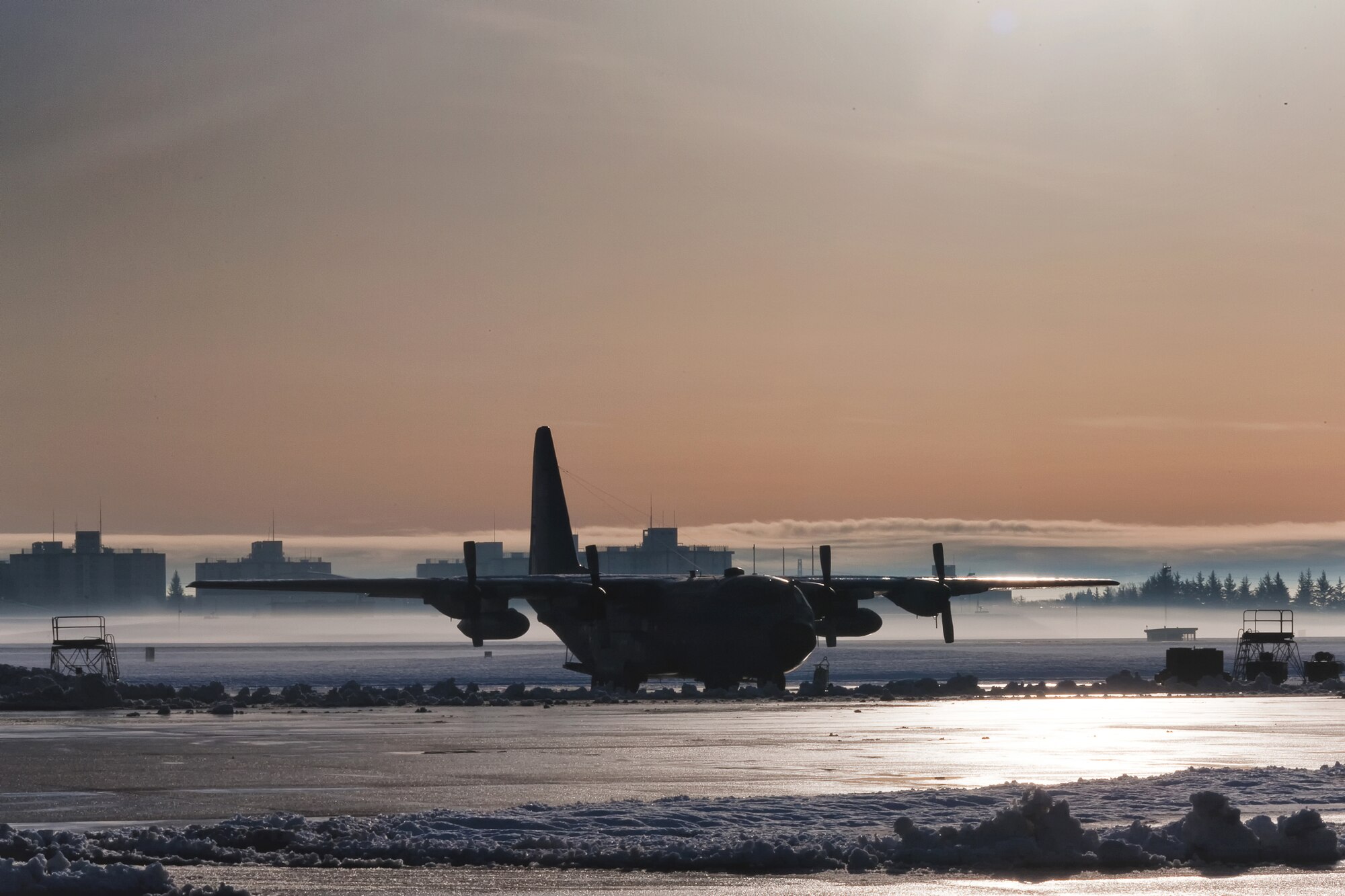 YOKOTA AIR BASE, Japan -- A C-130 Hercules sits on melting snow following a winter storm at Yokota Air Base, Japan, March 1, 2012. Eight and a half inches of snow fell in fifteen hours, causing base leadership to call out the plows to clear the runway, taxiways and roadways. According to the 374th Operations Support Squadron weather flight, the snowfall was caused from an abundance of moisture from "Shanghai Low", the low pressure system which usually moves along the southern coastline of Japan.  (U.S. Air Force photo/Osakabe Yasuo)