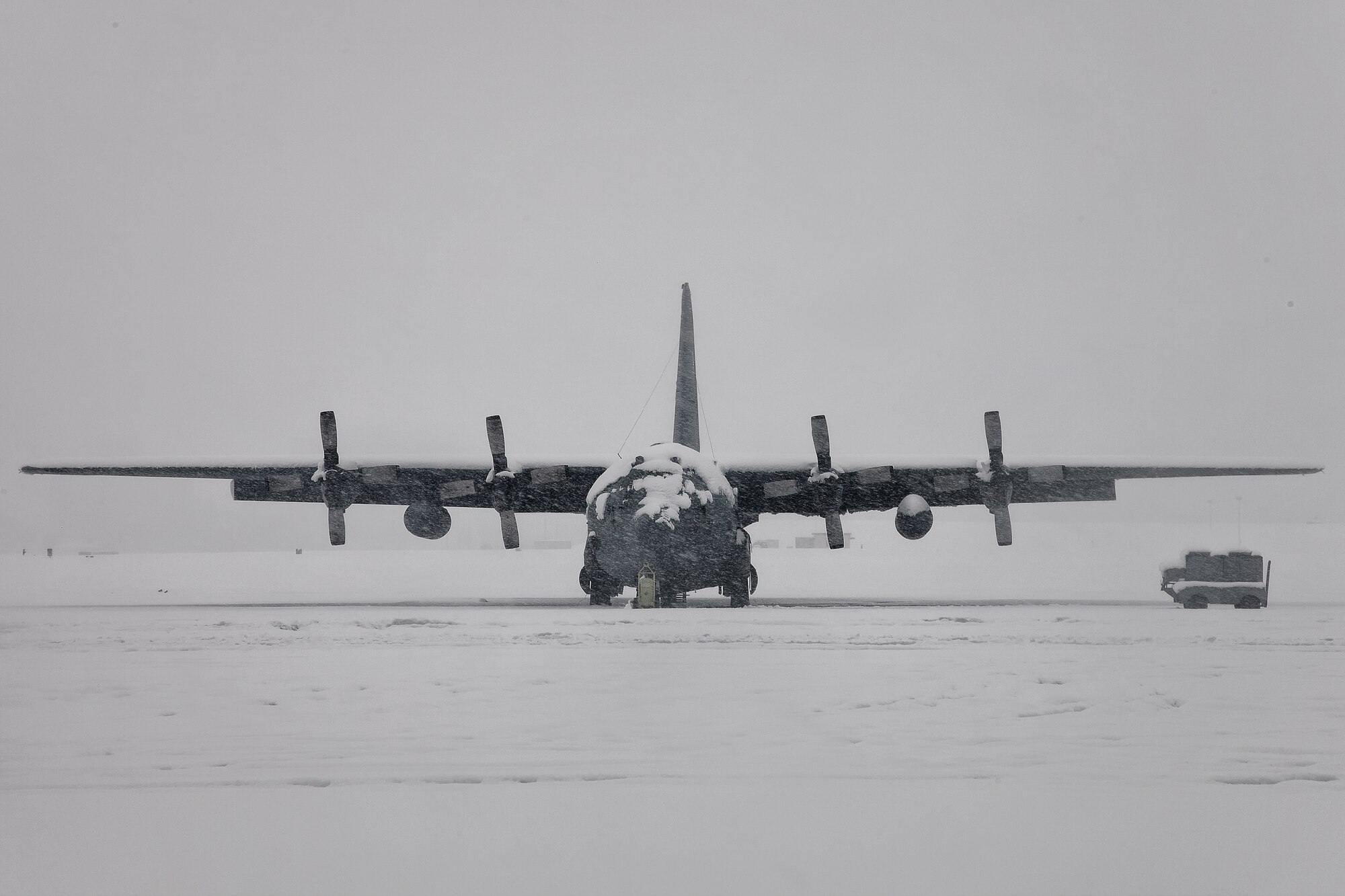 YOKOTA AIR BASE, Japan -- A snow-covered C-130 Hercules sits on the flight line at Yokota Air Base, Japan during a heavy snow fall, Feb. 29, 2012. Eight and a half inches of snow fell in fifteen hours, causing base leadership to call out the plows to clear the runway, taxiways and roadways. According to the 374th Operations Support Squadron weather flight, the snowfall was caused from an abundance of moisture from "Shanghai Low", the low pressure system which usually moves along the southern coastline of Japan.  (U.S. Air Force photo/Osakabe Yasuo)