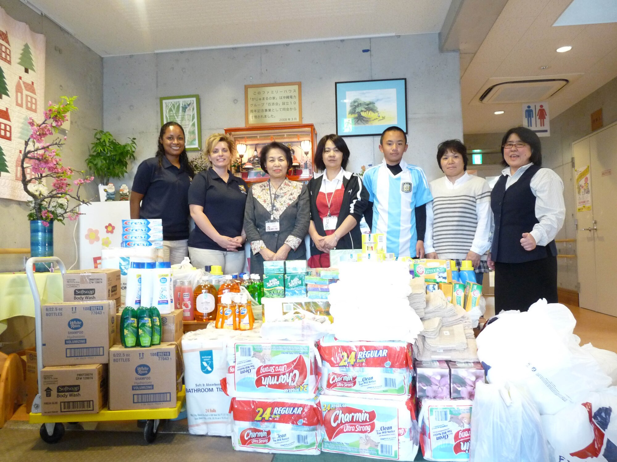 Technical Sgts. Melissa Schramm and Nichelle Hunter-Nichols stand with staff members from Family House Gajumaru and all the items they delivered to the facility on behalf of the Erwin Professional Military Education Center. The PME Center raised more than $800 to buy supplies for Family House Gajumaru, a low-cost lodging facility in Haebaru for families to stay while their child receives medical care at nearby Children’s Hospital or other hospitals on Okinawa Island. Many of the families who stay there come from smaller islands around Okinawa or the northern area of Okinawa. The PME center along with the Non-Commissioned Officer Academy class 12-2 and Airmen Leadership School class 12-B raised the money during Super Bowl weekend by asking students and staff to pay $1 a stripe to wear their favorite jersey. (U.S. Air Force photo by Keiko Toma/Released)