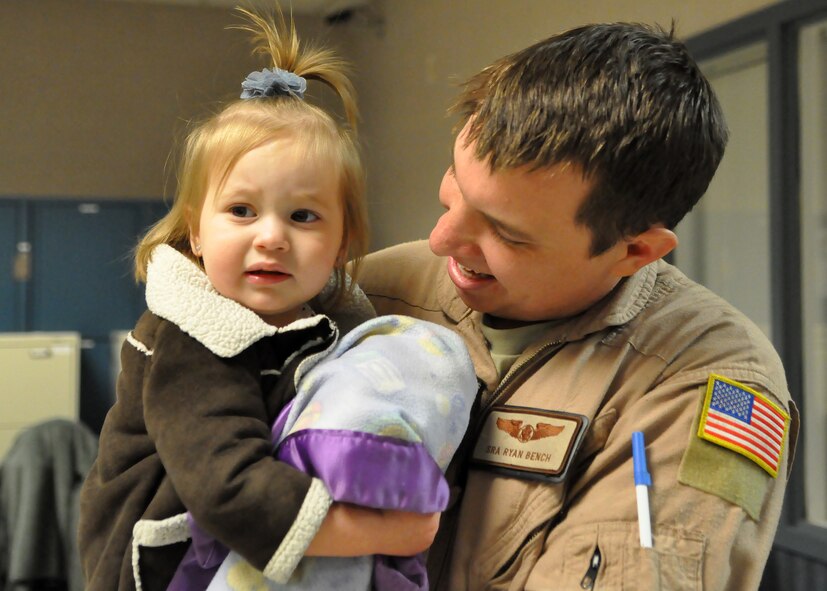 Senior Airman Ryan Bench, 7th Airlift Squadron loadmaster, greets his daughter after returning from a deployment Feb. 29, 2012, at Joint Base Lewis-McChord, Wash. While deployed as the 817th Expeditionary Airlift Squadron, their mission was to provide global strategic airlift, airdrop, aeromedical evacuation and humanitarian relief, to create an air bridge for personnel, equipment and supplies throughout the assigned areas of responsibility. (U.S. Air Force photo/Airman 1st Class Leah Young)