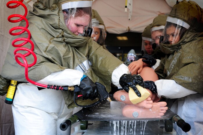 Members from the 628th Medical Group decontaminate a simulated patient during a timed trial to complete the In Place Patient Decontamination training at the clinic, Joint Base Charleston - Air Base, Feb. 23.  The training is designed to to prepare Airmen to provide care during a chemical, biological, radiological or nuclear catastrophe. (U.S. Air Force photo/ Staff Sgt. Nicole Mickle)  