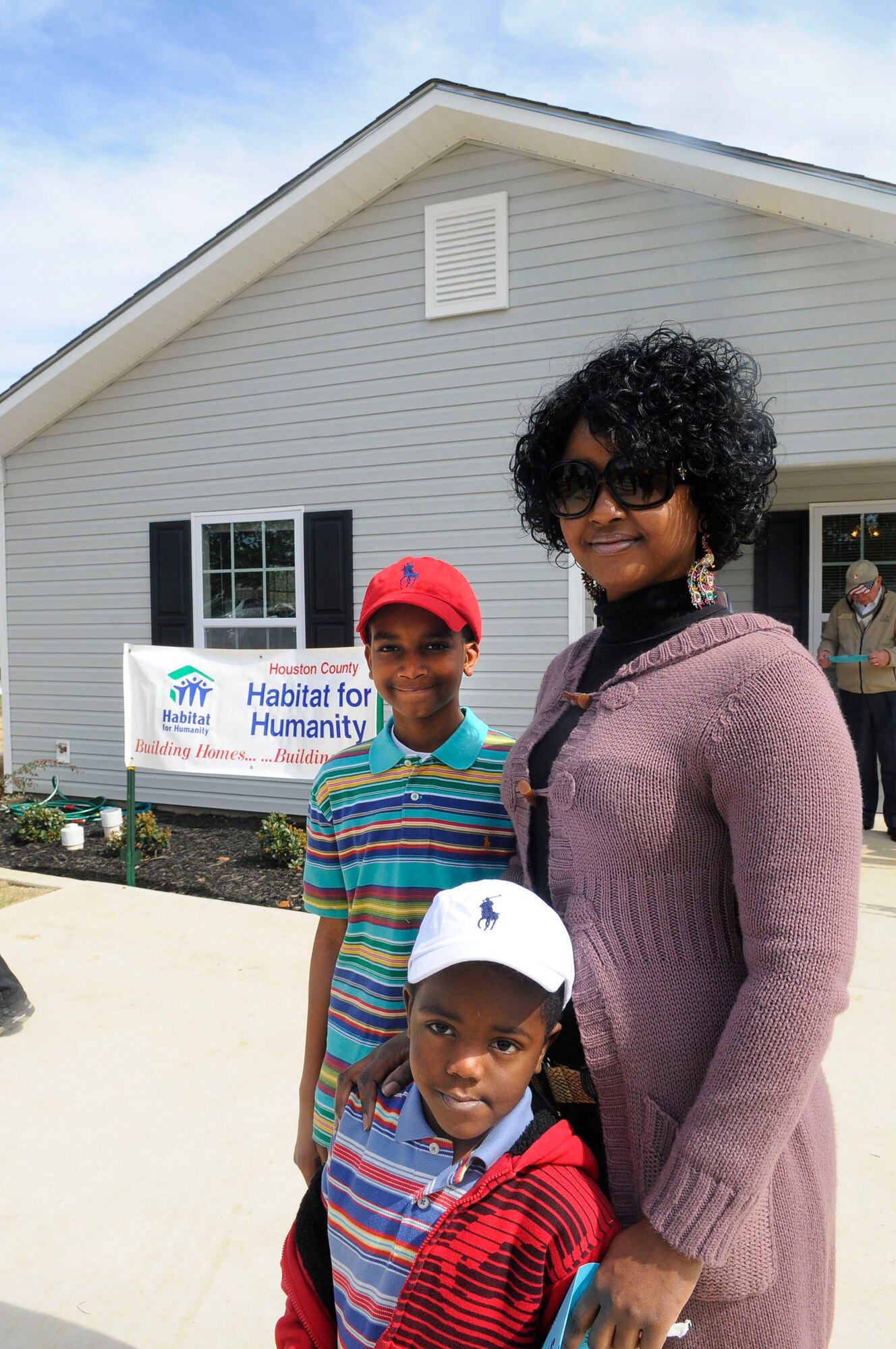 Dominique Toval, along with her sons Keynan and Christian, stands in front of of their new home Feb. 25. The home was built by Houston County Habitat for Humanity through sponsorship by Team Robins. U. S. Air Force photo by Sue Sapp