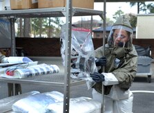 Senior Airman Kristin Bruce helps set up equipment during a timed trial to complete the In Place Patient Decontamination training at Joint Base Charleston, S.C., Feb. 23, 2012. The training is designed to prepare Airmen to provide care during a chemical, biological, radiological or nuclear catastrophe. The team was required to be fully operational in 20 minutes in order to pass the training. The 628th Medical Group team was able to accomplish the task in 12 minutes. Bruce is a 628th MDG dental assistant. (U.S. Air Force photo/Airman 1st Class Ashlee Galloway)
