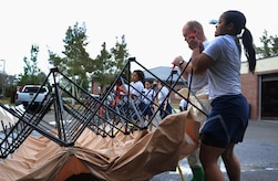 Staff Sgt. Satin Polanco helps lifts up a tent during a timed trial to complete the In Place Patient Decontamination training at Joint Base Charleston, S.C,  Feb. 23, 2012. The training is designed to prepare Airmen to provide care during a chemical, biological, radiological or nuclear catastrophe. The training requires teams to be fully operational in 20 minutes in order to pass the training. The 628th Medical Group team was able to accomplish the task  in 12 minutes. Polanco is a 628th MDG physical therapy technician. (U.S. Air Force photo/Airman 1st Class Ashlee Galloway)