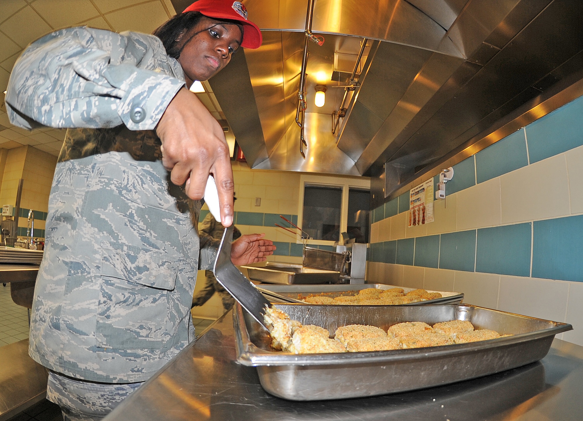 U.S. Air Force Airman Tyrica Earls prepares to put fish at the Southern Eagle dining facility on Seymour Johnson Air Force Base, N.C., Feb. 28, 2012. Dining facility members start preparing food about an hour before each meal. Earls, 567th RED HORSE Squadron food specialist, is completing 90 days of upgrade training and hails from Raleigh, N.C. (U.S. Air Force photo/Senior Airman Gino Reyes/Released)
