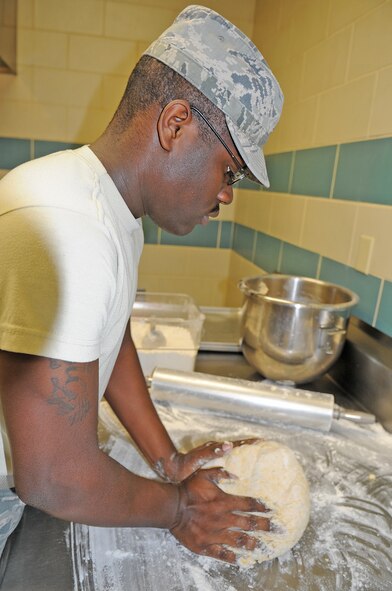 U.S. Air Force Airman 1st Class William Jenkins prepares cheesy biscuits at the Southern Eagle dining facility on Seymour Johnson Air Force Base, N.C., Feb. 28, 2012. Once a month the dining facility staff hosts a meal for spouses and children of deployed members giving them an opportunity to mingle with other spouses of deployed Airmen. Jenkins, 4th Force Support Squadron food specialist, hails from Charlotte, N.C. (U.S. Air Force photo/Senior Airman Gino Reyes/Released)