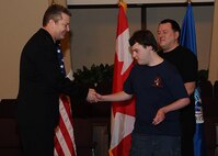 MINOT N.D. -- Marcus Anthony Cox was sworn in as an honorary special agent for his dedication and contributions to the law enforcement community at the First Assembly of God in Minot, Feb. 22. He was presented with a plaque, commemorating the event, by Mr. Peter Edge, Deputy Associate Director of Homeland Security Investigations. Ever since Cox was a young boy, he has always had the love and desire to be a part of the law enforcement community. Although faced with numerous medical challenges which he has overcome, he continues to volunteer his time to support Minot’s emergency services. Marcus’ plans for the future include staying connected to the emergency services and finding a way to actively be a part of helping to take care of people and to help keep them safe. (U.S. Air Force photo/Airman 1st Class Kristoffer Kaubisch)