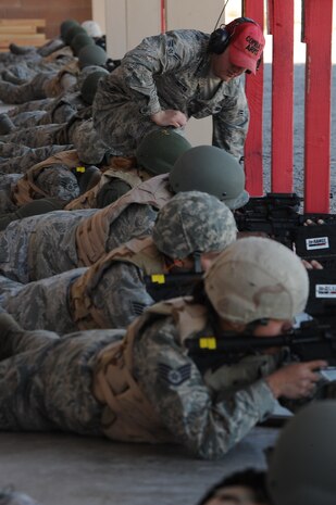 Airman 1st Class George Hudyma, 99th Security Forces Group combat arms instructor, monitors a shooter's form during combat arms training Feb. 24 at Nellis Air Force Base, Nev. The combat arms course curriculum changed Dec. 1, 2011. (U.S. Air Force photo by Senior Airman Jack Sanders)