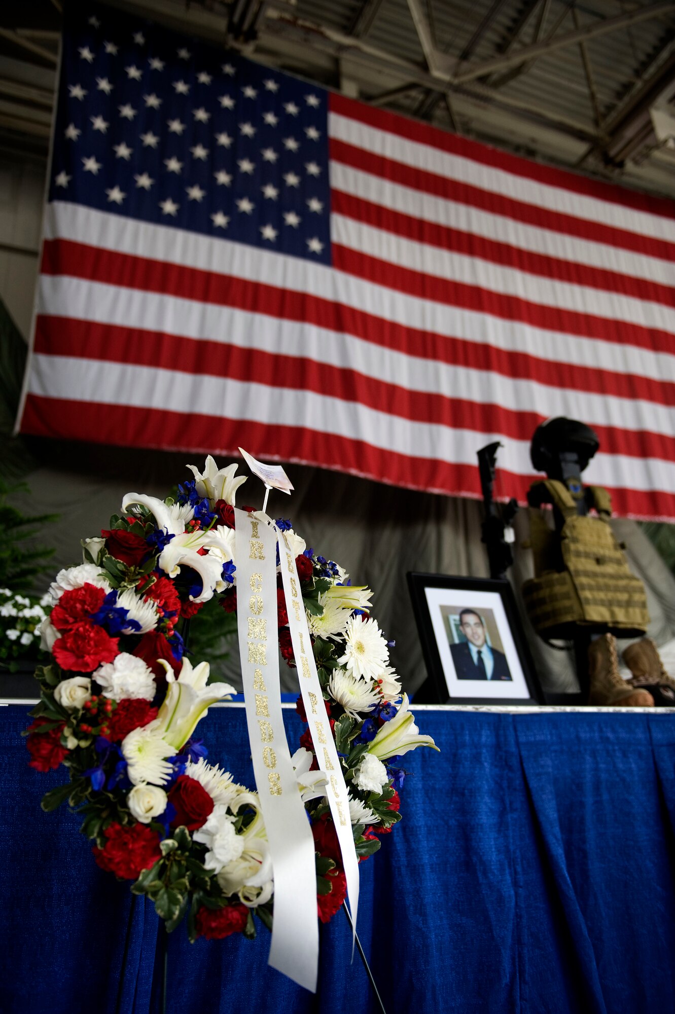 A wreath of flowers stands near a memorial display in the Freedom Hangar at Hurlburt Field, Fla., Feb. 28, 2012.  The wreath and articles of clothing are presented as a memorial to the service and sacrifice of the fallen Airmen in the Feb. 18, 2012, U-28A crash. (U.S. Air Force photo/Airman 1st Class Gustavo Castillo)(Released)