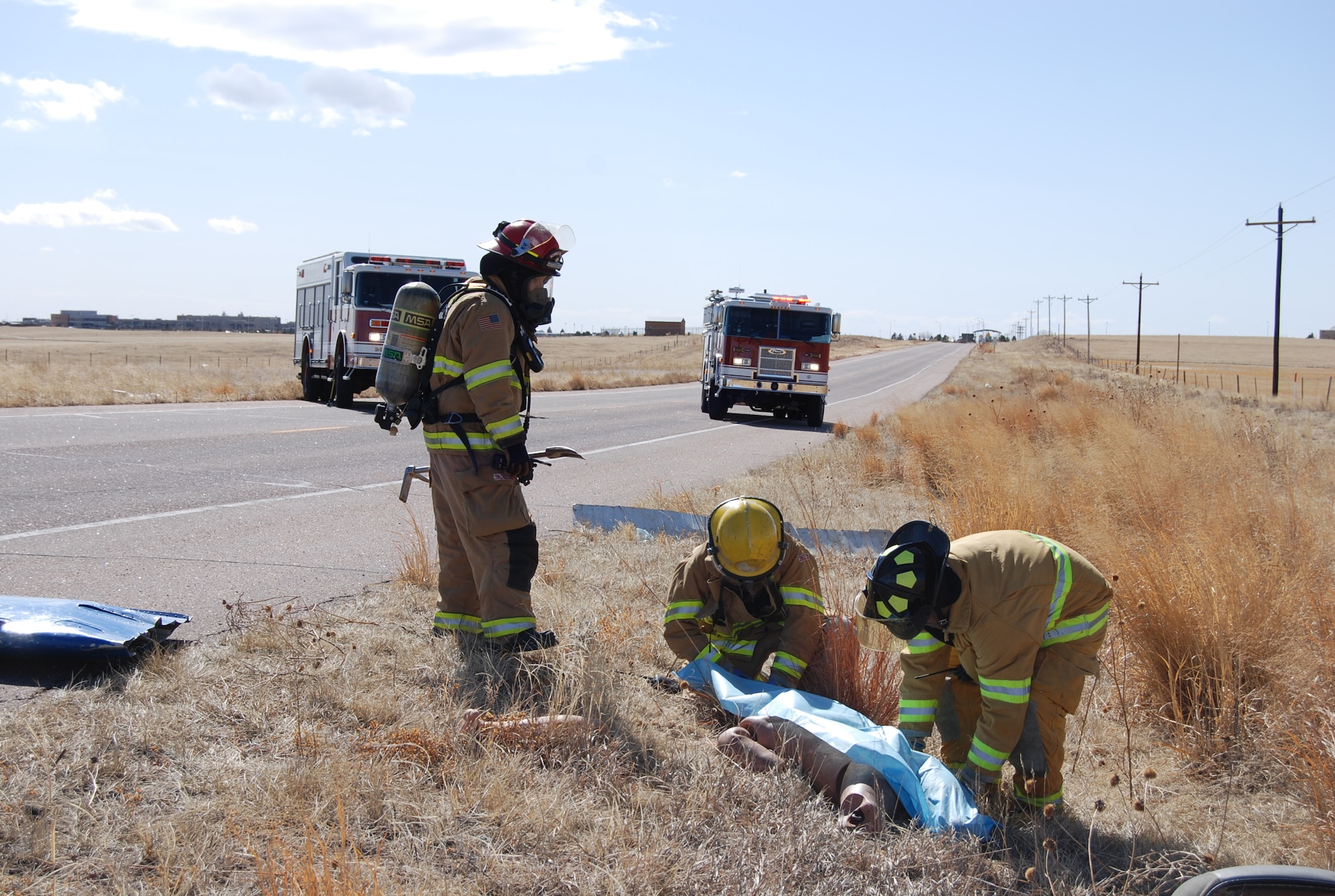 SCHRIEVER AIR FORCE BASE, Colo. — Members of the Schriever Air Force Base fire department treat a simulated casualty from a small aircraft crash near the Schriever AFB west gate, Feb. 28. The aircraft crash scenario was part of the Condor Crest readiness and preparedness exercise, to train and educate Air Force personnel to respond to crises and defend the installation. (U.S. Air Force photo/Lea Johnson)