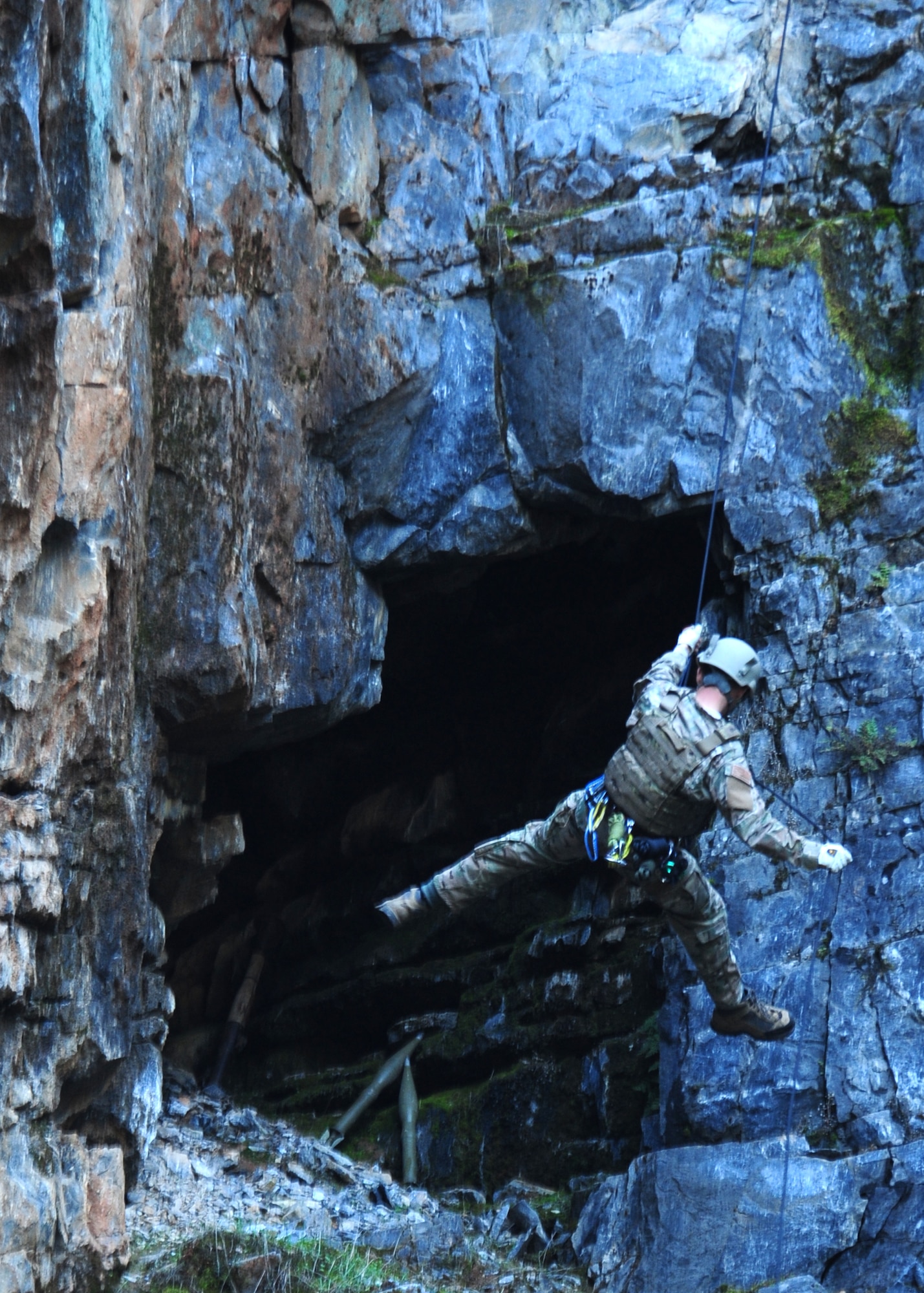 Master Sgt. Arin Finch, 9th Civil Engineer Squadron explosive ordnance disposal flight chief, repels into a cave on the side of a cliff during mountain warfare training in Auburn, Calif., Feb. 17, 2012. Finch and his team simulated a situation where a Hellfire missile neutralized an enemy location, leaving a casualty and a weapons cache to be removed. (U.S. Air Force photo by Senior Airman Shawn Nickel/Released)