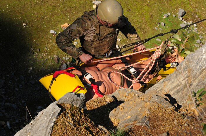 Staff Sgt. Scott Love, 9th Civil Engineer Squadron explosive ordnance disposal technician from Beale Air Force Base, Calif., carefully guides a practice victim down a cliff during mountain warfare training in Auburn, Calif., Feb 17, 2012. Beale's EOD flight trains extensively on the removal of casualties, explosives and weapons caches from mountainous terrain. (U.S. Air Force photo by Airman 1st Class Rachael Kane/Released)